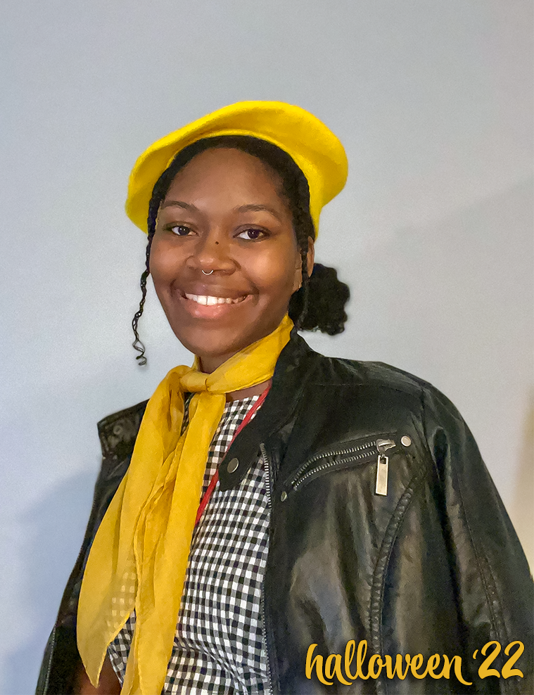 a photo of a the owner of this site during halloween, smiling, and wearing a yellow chiffon scarf, barret and black leather jacket